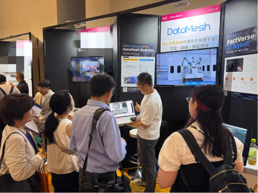 Visitantes observan una demostración de robótica y gemelo digital industrial de DataMesh